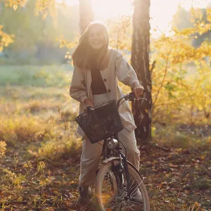 Happy active young woman riding vintage bicycle in autumn park at sunset Happy active young woman riding vintage bicycle in autumn park at sunset