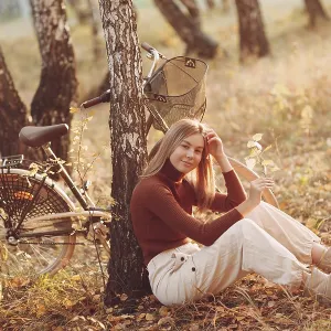 Happy active young woman riding vintage bicycle in autumn park at sunset Happy active young woman riding vintage bicycle in autumn park at sunset