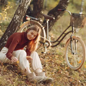 Happy active young woman riding vintage bicycle in autumn park at sunset Happy active young woman riding vintage bicycle in autumn park at sunset