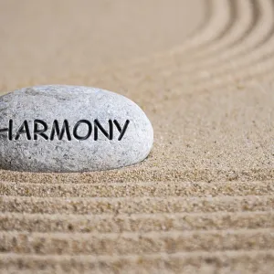Harmony text engraved on Zen stone on sand