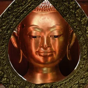 Head of a golden Buddha figure seen through a metal ring Wat Yai Chai Mongkol Ayutthaya Thailand Head of a golden Buddha figure seen through a metal ring Wat Yai Chai Mongkol Ayutthaya Thailand