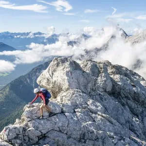 Hiker with climbing helmet on a steep hiking trail Hiker with climbing helmet on a steep hiking trail