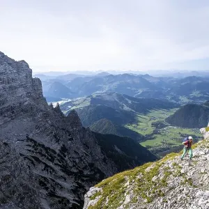 Hiker on a hiking trail, view over mountain landscape Hiker on a hiking trail, view over mountain landscape