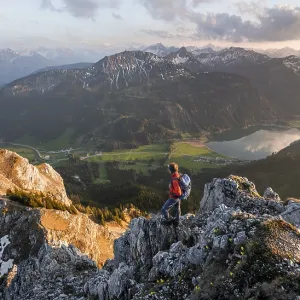 Hiker at the summit of Schartschrofen at sunset