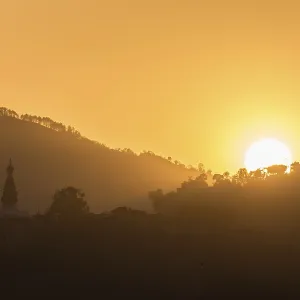 Hills with trees and buddhist temple at sunset