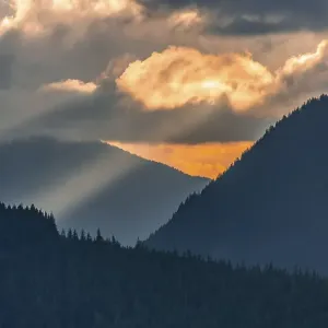 Hilly wooded mountain landscape at sunset with dramatic clouds