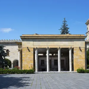 Historic building with columns and Georgian flag in clear blue sky