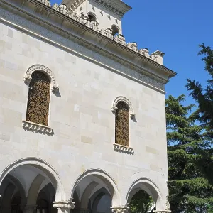Historic building with decorated facade and a flag against a blue sky
