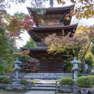 Historic Japanese temple with stepped pagoda surrounded by autumn trees Historic Japanese temple with stepped pagoda surrounded by autumn trees
