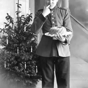 Historic photograph, person in uniform in front of a Christmas tree Historic photograph, person in uniform in front of a Christmas tree