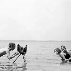 Historic photograph, photographer taking a picture of two women in the sea Historic photograph, photographer taking a picture of two women in the sea