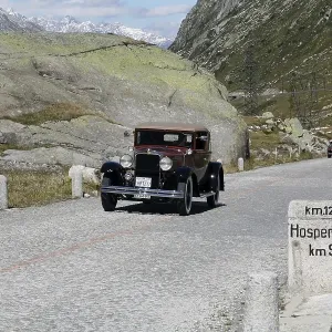 Historic section of cobblestone pavement on the old Gotthard pass route with milestone to Hospental and Oldtimer Historic section of cobblestone pavement on the old Gotthard pass route with milestone to Hospental and Oldtimer