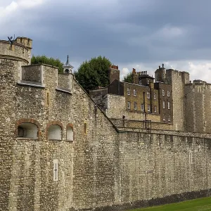 Historic stone wall and towers under a cloudy sky at The Tower of London