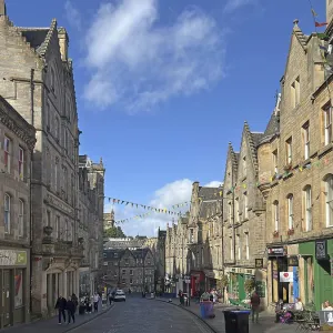 Historic street lined with old buildings under a clear sky Historic street lined with old buildings under a clear sky