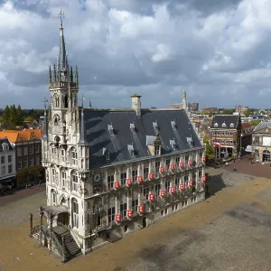 Historic town hall on an empty market square with gothic architecture and cloudy sky