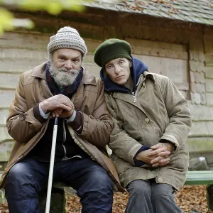 Homeless couple in front of a forest hut