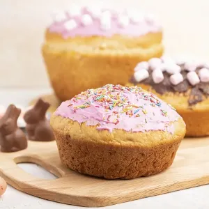 Homemade glazed and decorated easter pies with chocolate eggs and rabbits on a white concrete background