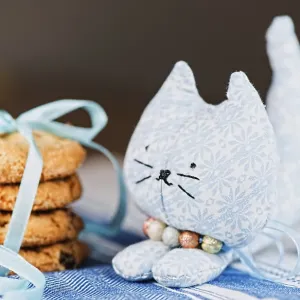 Homemade puppet, a cat and cookie on tablecloth Homemade puppet, a cat and cookie on tablecloth