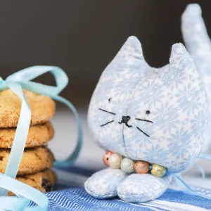 Homemade puppet, a cat and cookie on tablecloth Homemade puppet, a cat and cookie on tablecloth