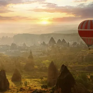 Hot air balloon over volcanic tuff rock formations at dawn Hot air balloon over volcanic tuff rock formations at dawn