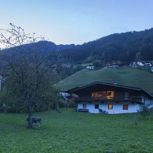 Houses, meadow and mountains with holiday home at dusk Houses, meadow and mountains with holiday home at dusk