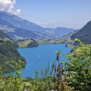 Idyllic landscape with blue lake in a valley surrounded by mountains under a clear sky