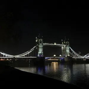 Illuminated Tower Bridge over a calm River Thames at night