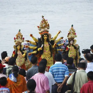 Immersion of Durga clay model with statues of kartikeya ganesha and lakshmi saraswati on immersion