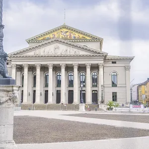 An impressive building with columns in the centre of Munich under a cloudy sky