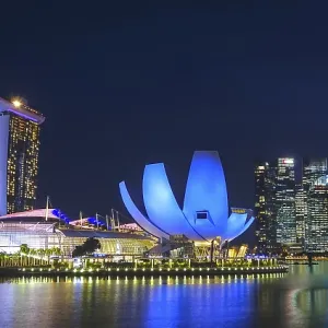Impressive city view at night with illuminated modern buildings and a tranquil expanse of water Impressive city view at night with illuminated modern buildings and a tranquil expanse of water