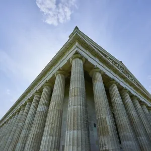 Impressive columned building that stands out against a light-flooded sky