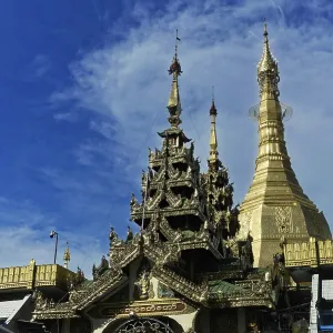 An impressive temple with a golden pagoda and detailed architecture under a blue sky
