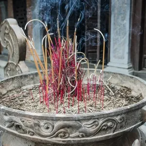 Incense sticks burning in a container in front of a Buddhist temple at Trang An Grottoes in the Trang An Scenic Incense sticks burning in a container in front of a Buddhist temple at Trang An Grottoes in the Trang An Scenic