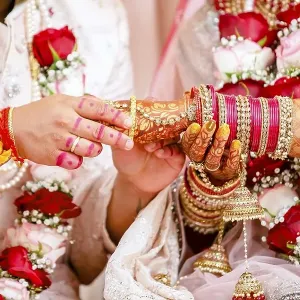 Indian groom passing bangles on his brides hand on her wedding ceremony Indian groom passing bangles on his brides hand on her wedding ceremony