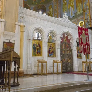 Interior view of an Orthodox church with icons and sacred objects in front of an altar