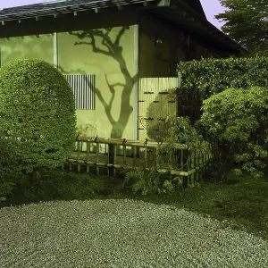 Japanese house wall with tree shadow and traditional circle pattern on the sand in zen garden by night time