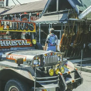 Jeepney minibus in front of a restaurant with skewered suckling pig