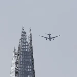 Jet passenger aircraft in flight over The Shard skyscraper building Jet passenger aircraft in flight over The Shard skyscraper building