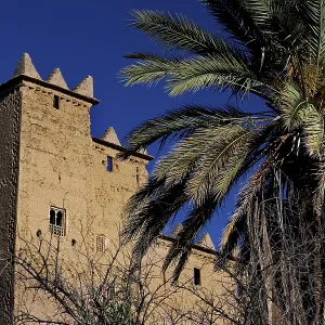 Kasbah Ait Abou Ali in Skoura with high walls and palm trees