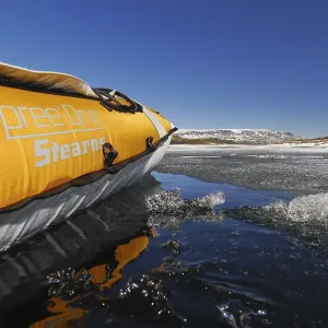 Side of a kayak reflected on a lake with ice floes Side of a kayak reflected on a lake with ice floes
