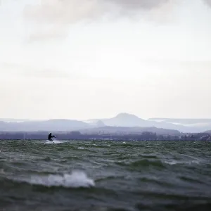 Kite surfers far away on rough water