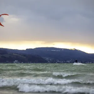 Kitesurfer at sunset, wavy water