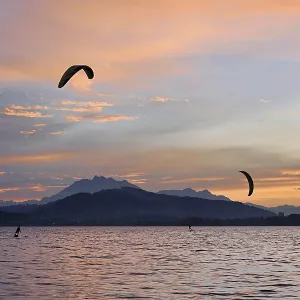 Two kitesurfers on Lake Zug at sunset