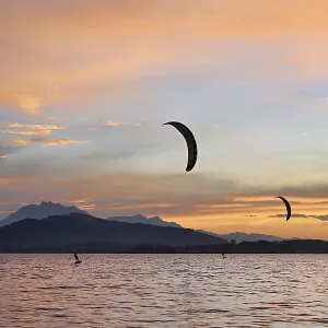 Two kitesurfers on Lake Zug at sunset