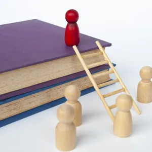 Ladder of success concept with books and doll figure climbing books with ladder