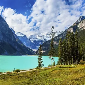 The lake with azure water is surrounded by mountains and forests