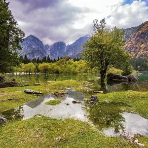 The lake shores are flooded. The mountains are covered with low clouds