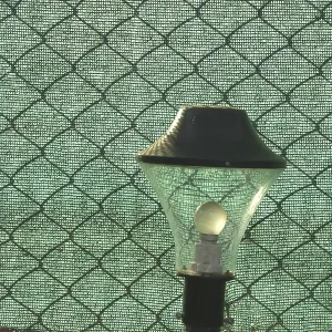Lampshade against crossed mesh and green cloth at holiday resort