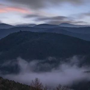 Landscape shot with cloudy sky and fog in the valley