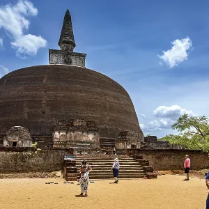 Large ancient stupa with people in the foreground on a sunny day Large ancient stupa with people in the foreground on a sunny day